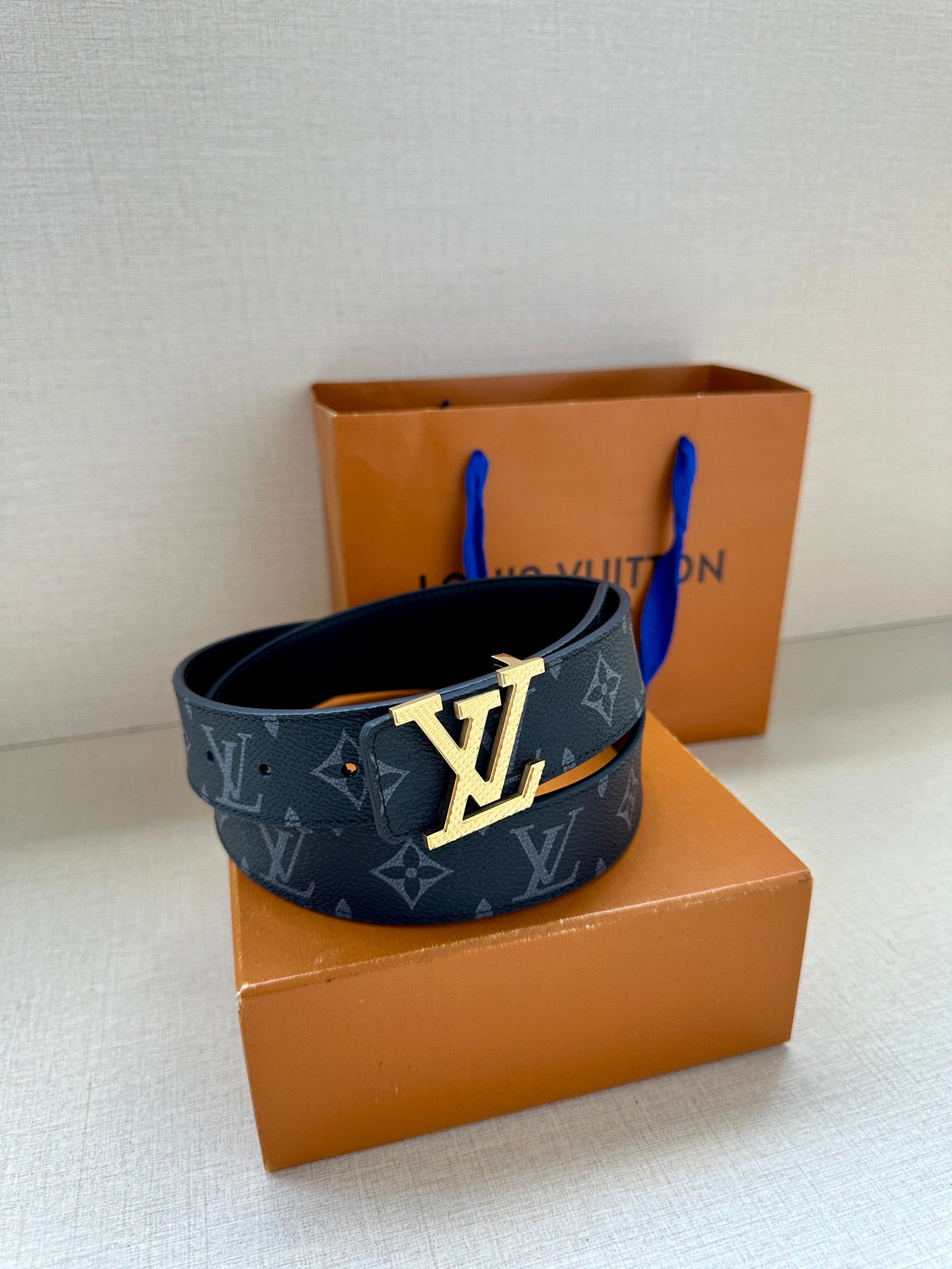 Louis Vuitton belt styled with dark navy monogram strap and oversized silver LV buckle