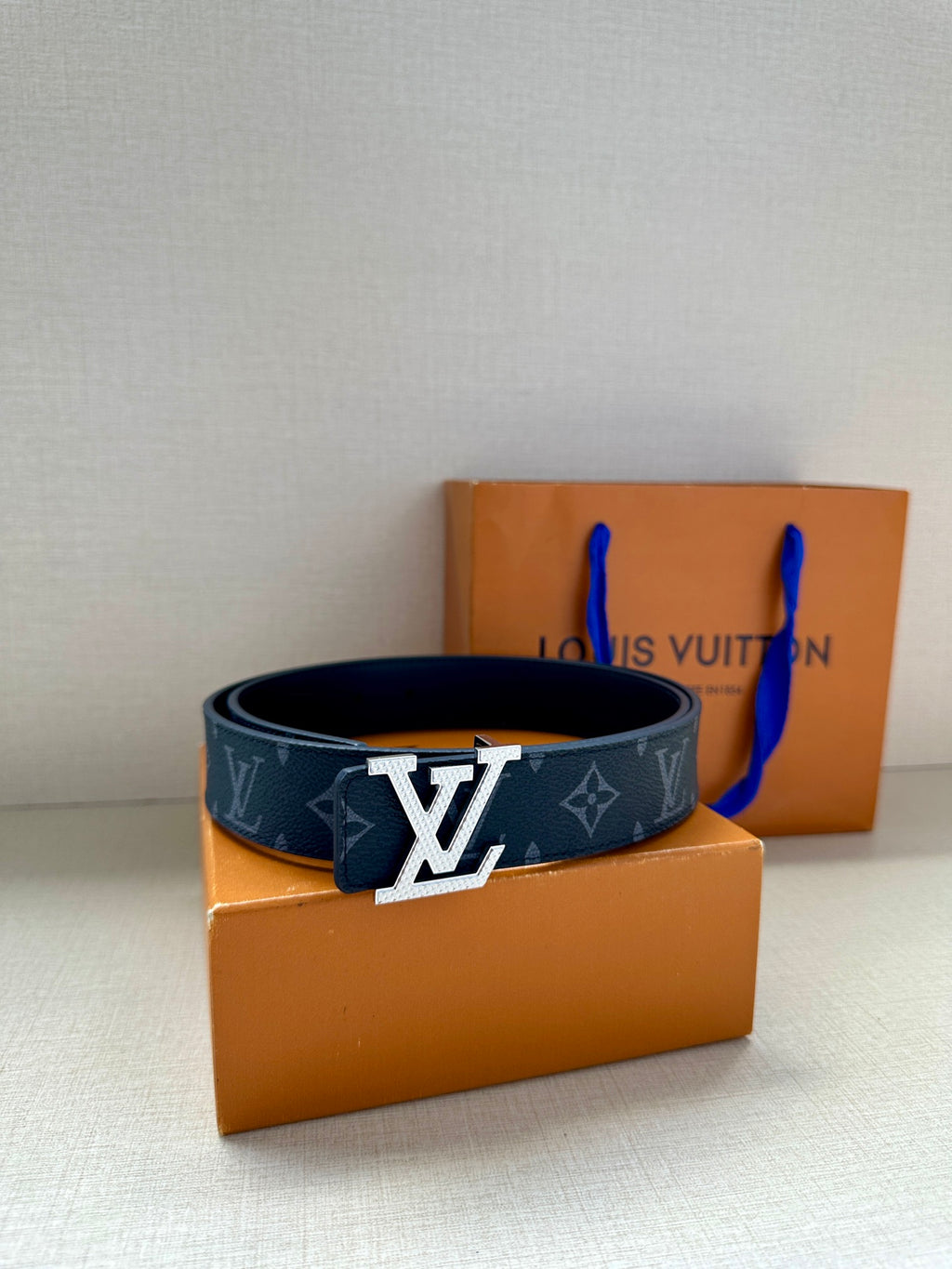 Louis Vuitton belt with dark navy monogram pattern and large silver LV buckle on strap