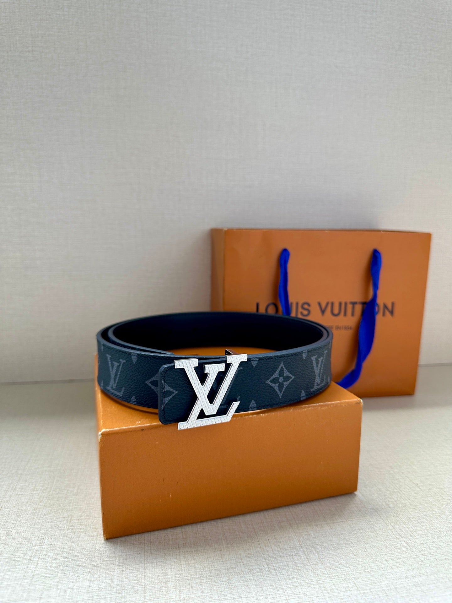 Louis Vuitton belt with dark navy monogram pattern and large silver LV buckle on strap