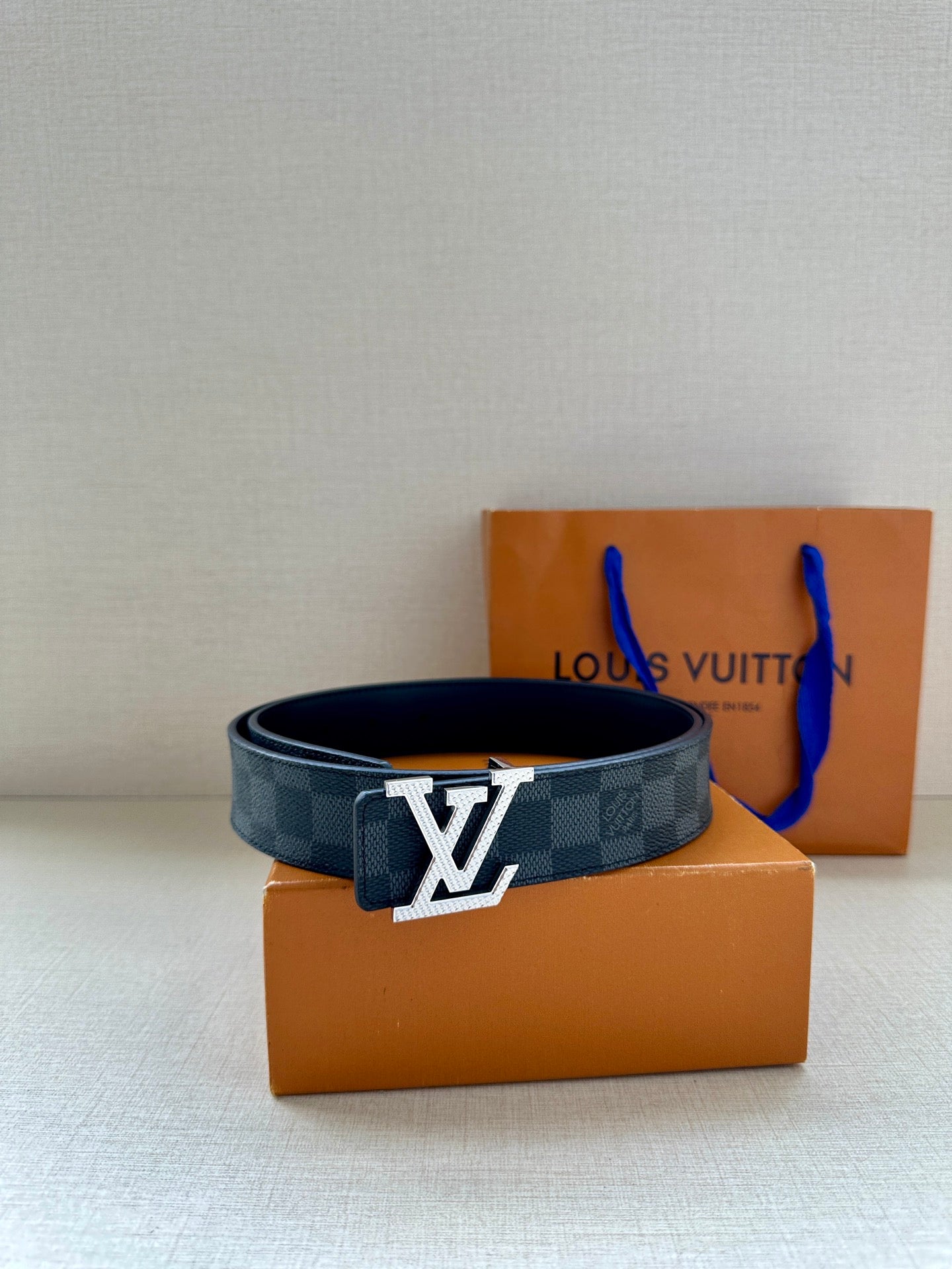 Louis Vuitton checkered leather belt with LV buckle, centered front view.