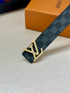 Louis Vuitton checkered belt with gold-toned LV buckle detail and strap edge.