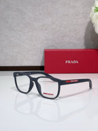 Dark blue eyeglasses with Prada mark on temple and red accent, rectangular frame.