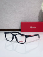 Navy eyeglasses with red Prada logo on temple, rectangular full-rim frame.