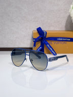 Aviator sunglasses with dark lenses, blue metal frame, rhinestone detail at temples.