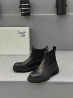 Black Chelsea boots with elastic gores and thick tread sole