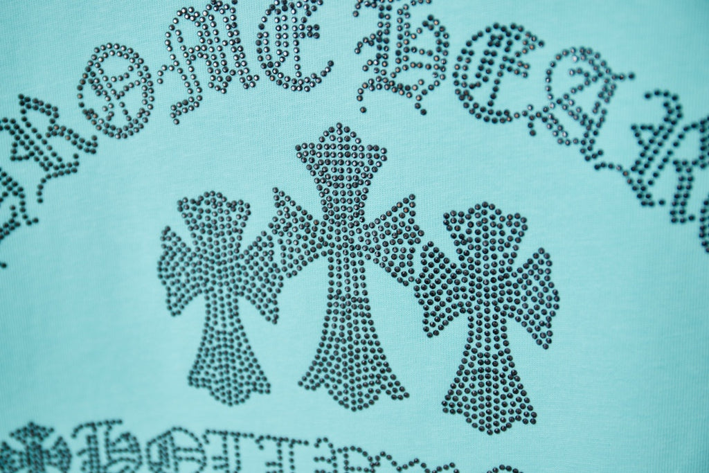 Turquoise T-shirt close-up of rhinestone-style text and bows graphic