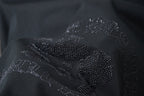 Close-up of rhinestone flower logo on dark T-shirt