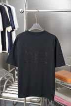 Dark short-sleeve T-shirt with large rhinestone floral logo across the chest