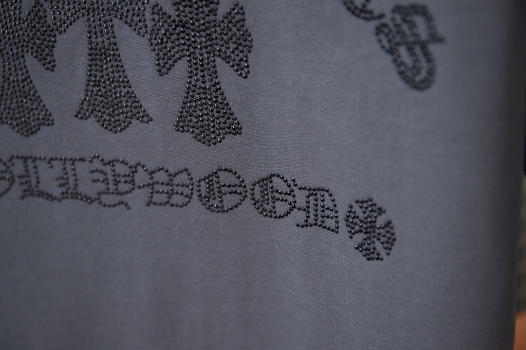 Close-up of rhinestone back graphic text on dark gray short-sleeve T-shirt