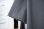 Short-sleeve T-shirt hem detail in dark gray, with neat double stitching