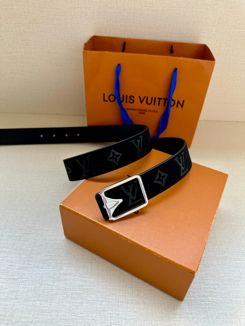 Black monogram belt with silver-tone square buckle, angled front view