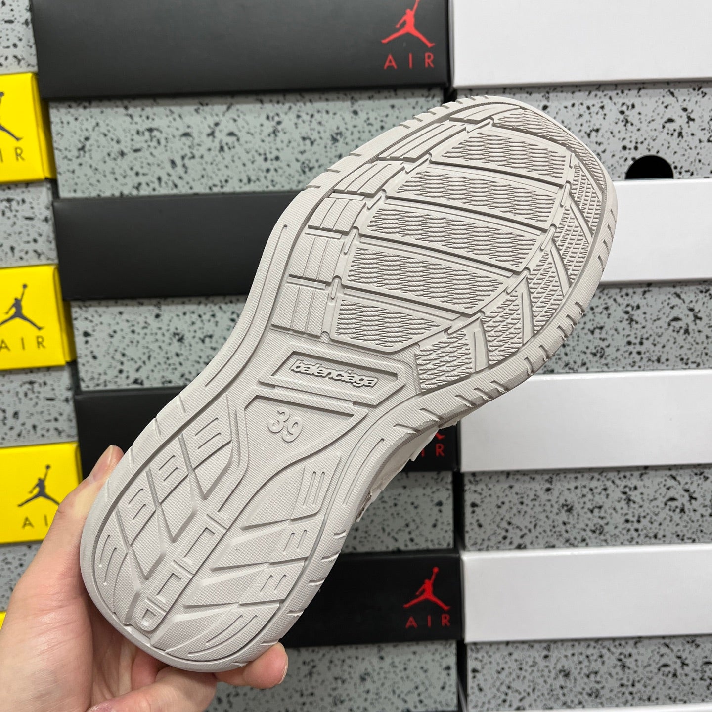 White Balenciaga sneaker outsole with tread pattern and embossed branding.