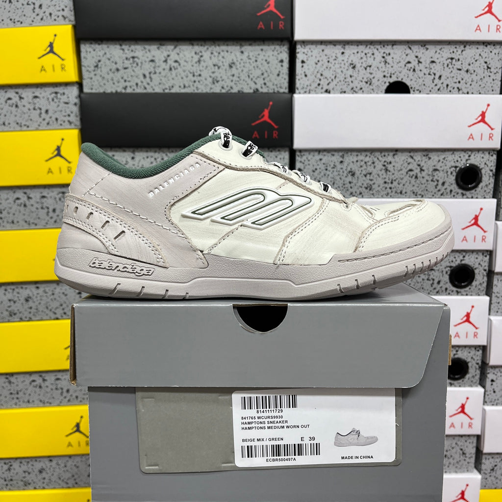 White Balenciaga low-top sneakers with green tongue lining, lace-up front view.