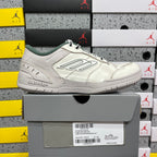 White Balenciaga low-top sneakers with green tongue lining, lace-up front view.