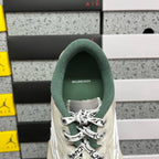 White Balenciaga sneaker heel with green fabric collar and lace-up opening.
