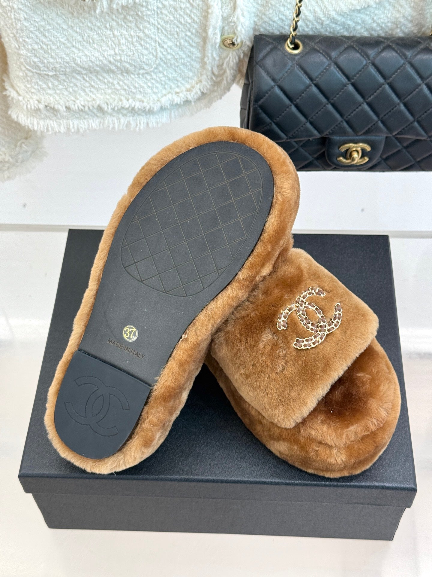 Brown plush slide slipper with textured sole and Chanel CC logo strap