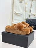 Brown plush slide slippers with Chanel rhinestone CC logo on front strap