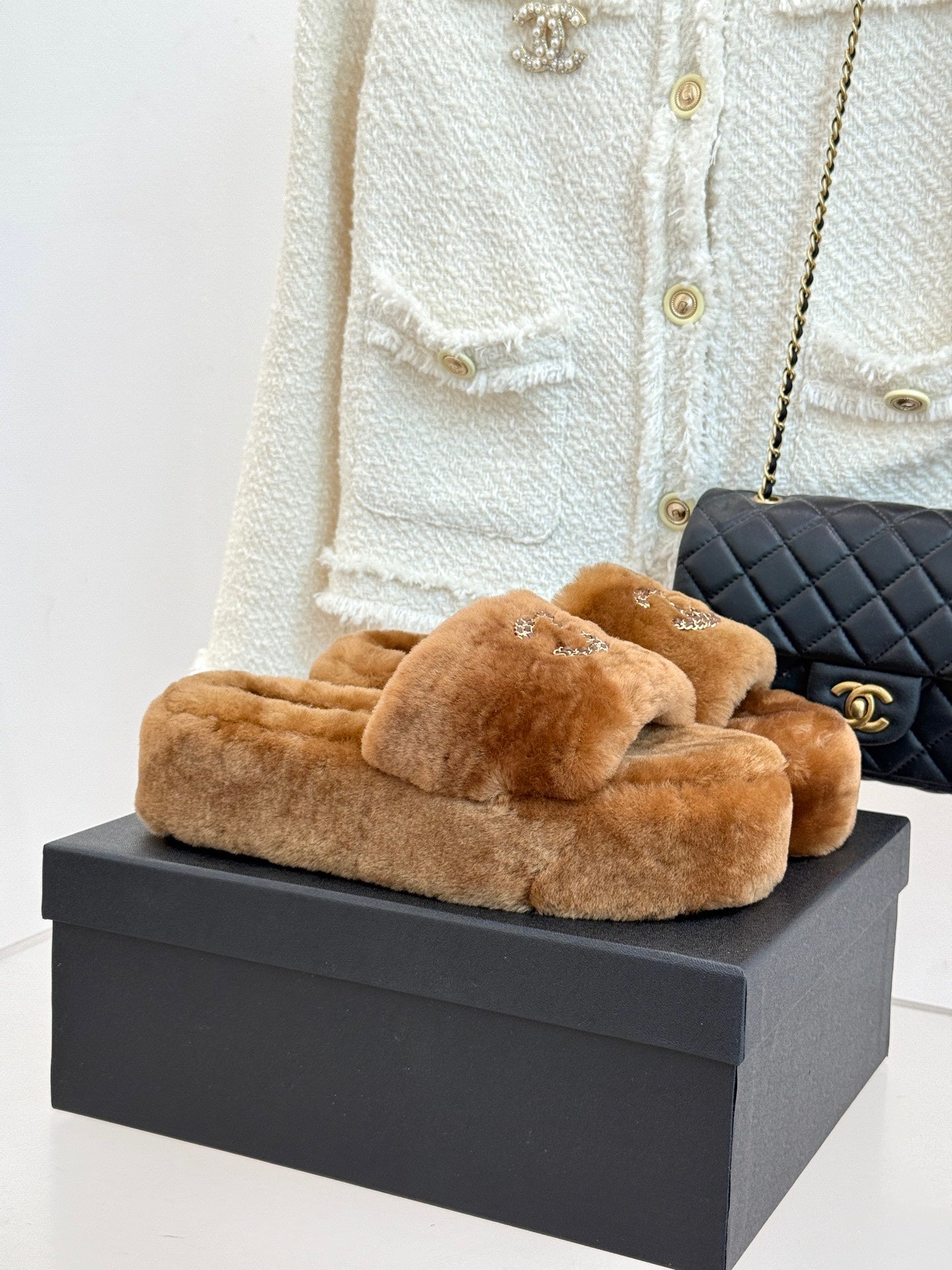 Brown plush slide slippers with Chanel rhinestone CC logo on front strap