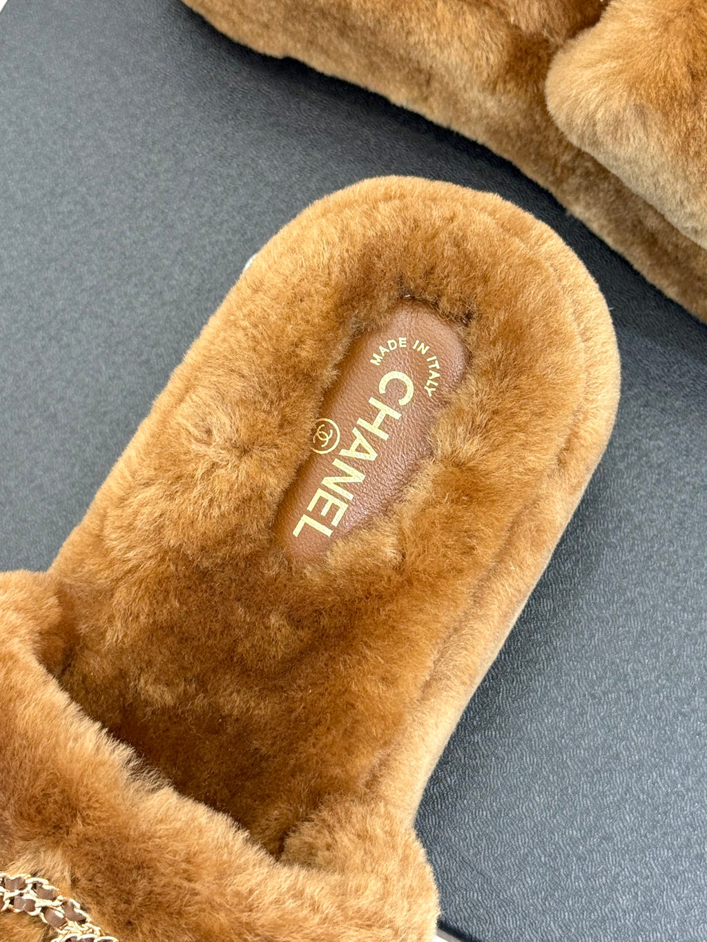 Brown plush slide slipper insole with CHANEL branding text
