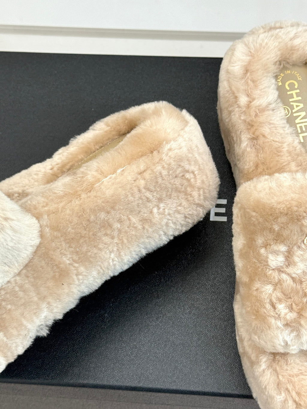 Beige faux fur slide sandal with brand text on the insole