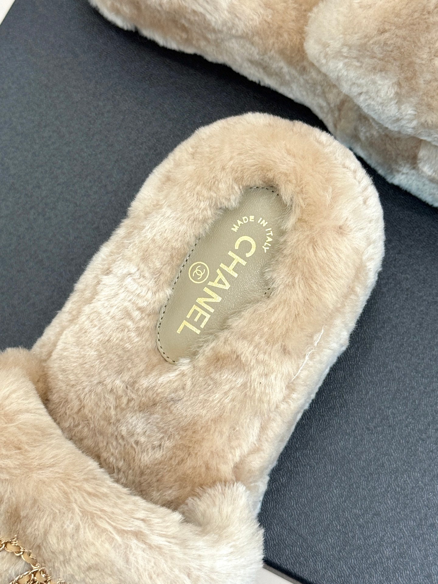 Beige faux fur slide sandal with Chanel-branded insole lettering