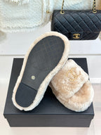 Beige faux fur slide sandals with gripped sole and gold logo on strap