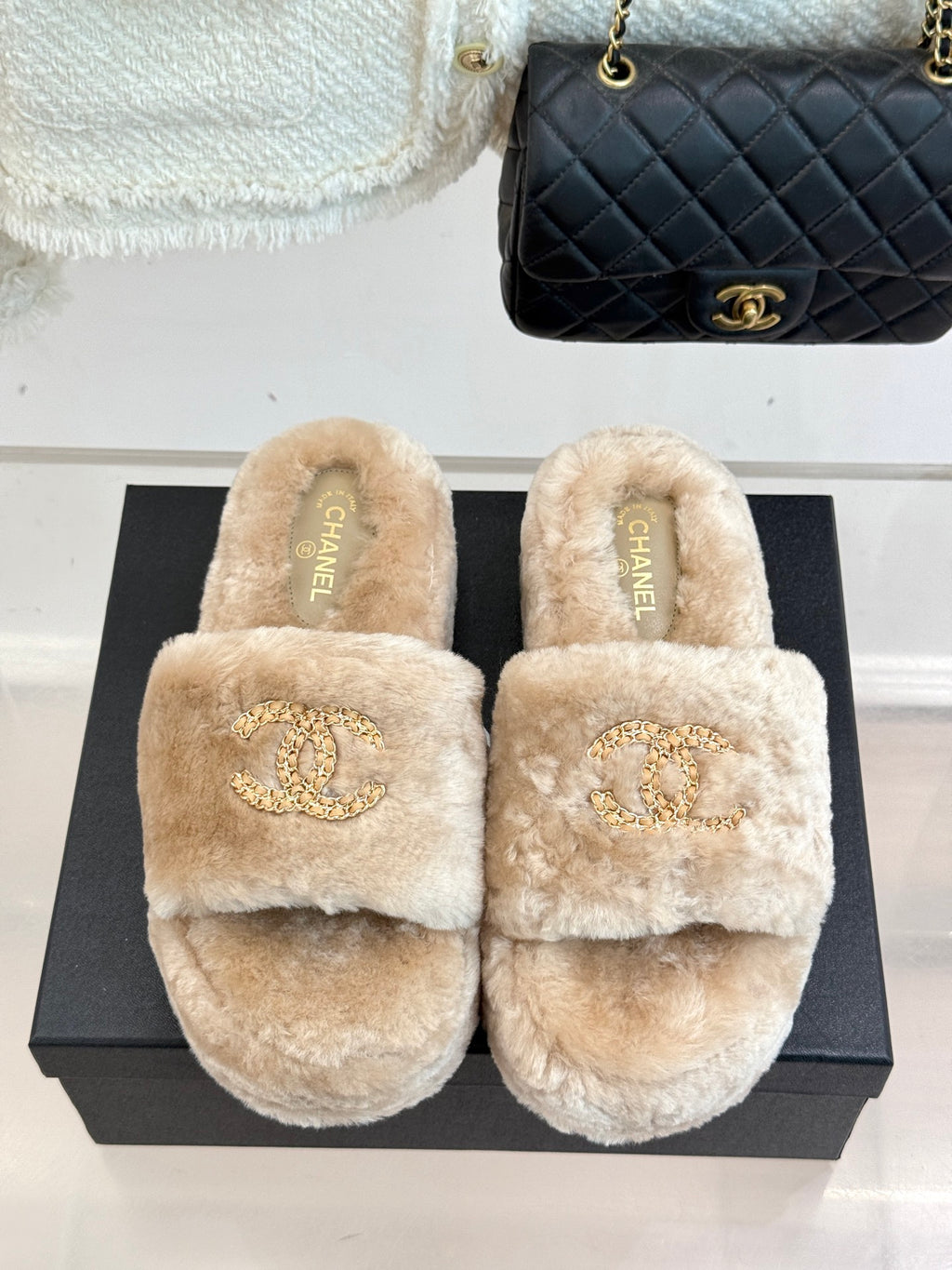 Beige plush slide sandals with Chanel logo embroidery on the strap