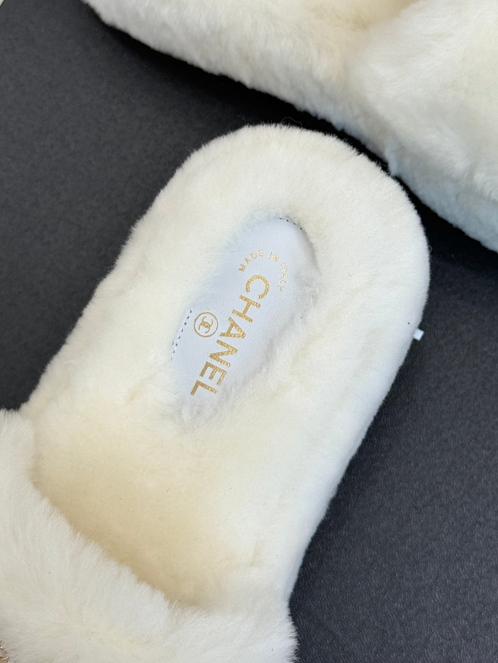 White faux-fur slide sandal with CHANEL logo on insole