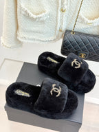 Black faux-fur CHANEL slide sandals with gold-tone logo embroidery on the straps