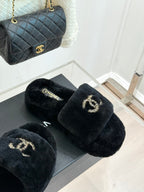 Black plush CHANEL slide sandals with a gold-tone logo on the front strap