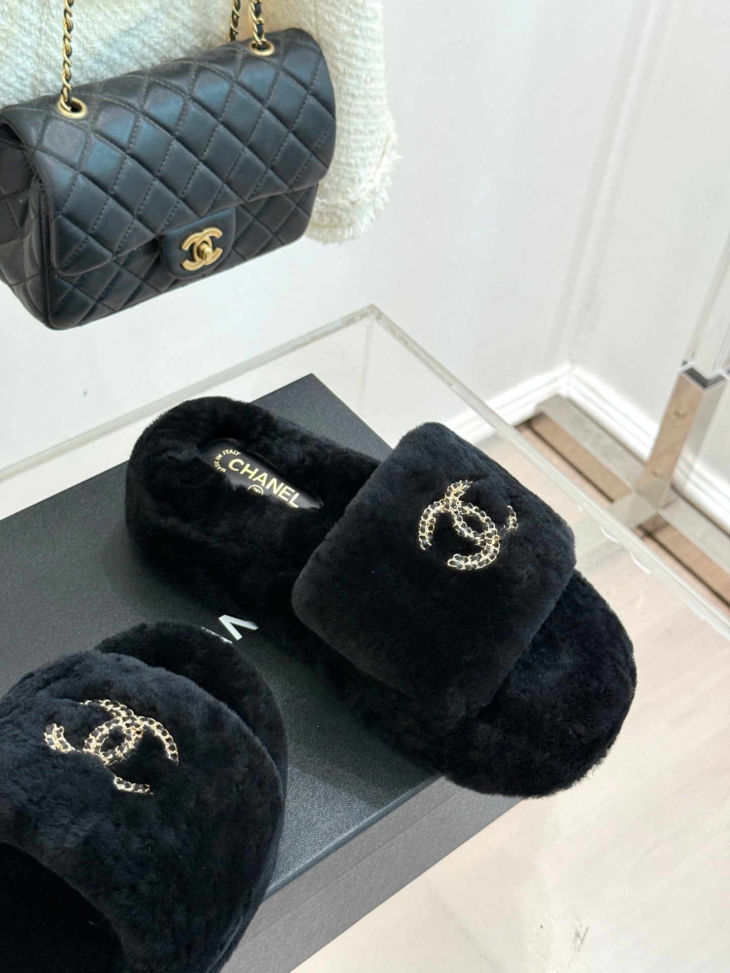 Black plush CHANEL slide sandals with a gold-tone logo on the front strap