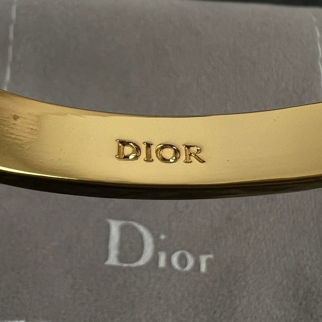 Dior engraved inside of gold-tone hinged bangle cuff