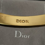Dior engraved inside of gold-tone hinged bangle cuff