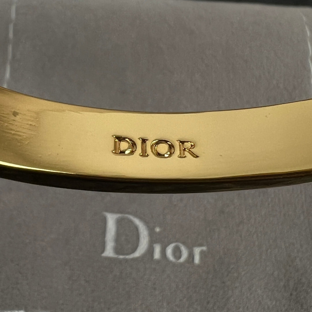 Dior engraved inside of gold-tone hinged bangle cuff