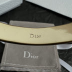 Gold-tone Dior bangle bracelet inner engraving, close-up of the band.