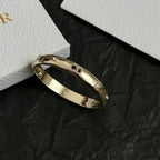 Gold-tone Dior bangle bracelet with clear stones, angled view.