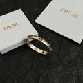 Gold-tone Dior bangle bracelet with clear stones, open hinged cuff.