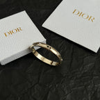 Gold-tone Dior bangle bracelet with clear stones, open hinged cuff.