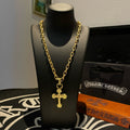 Gold-tone cross pendant necklace on a black display bust