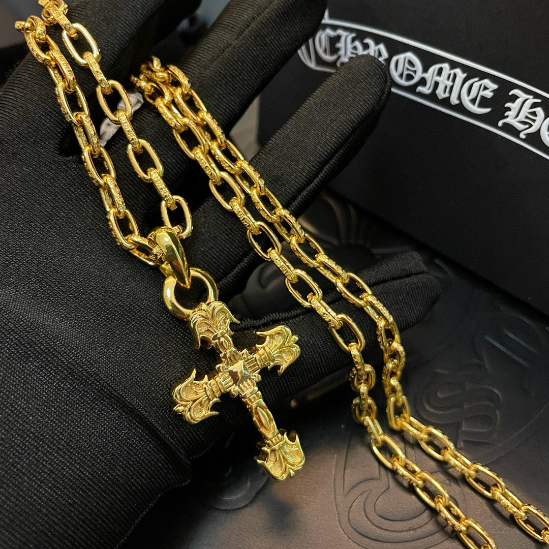 Gold-tone cross pendant necklace on a black fabric glove