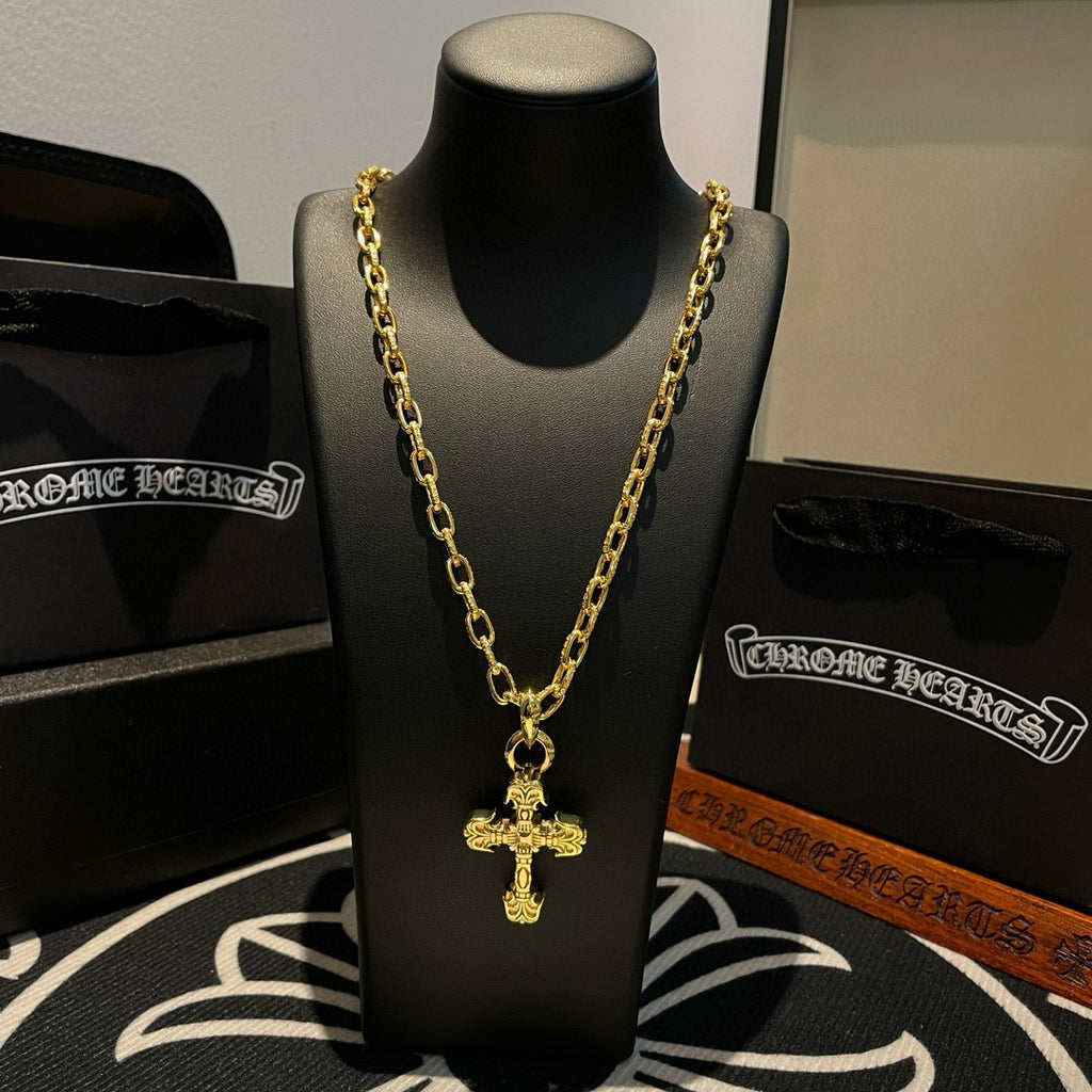 Gold-tone cross pendant necklace centered on a black display bust