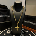Gold-tone cross pendant necklace centered on a black display bust