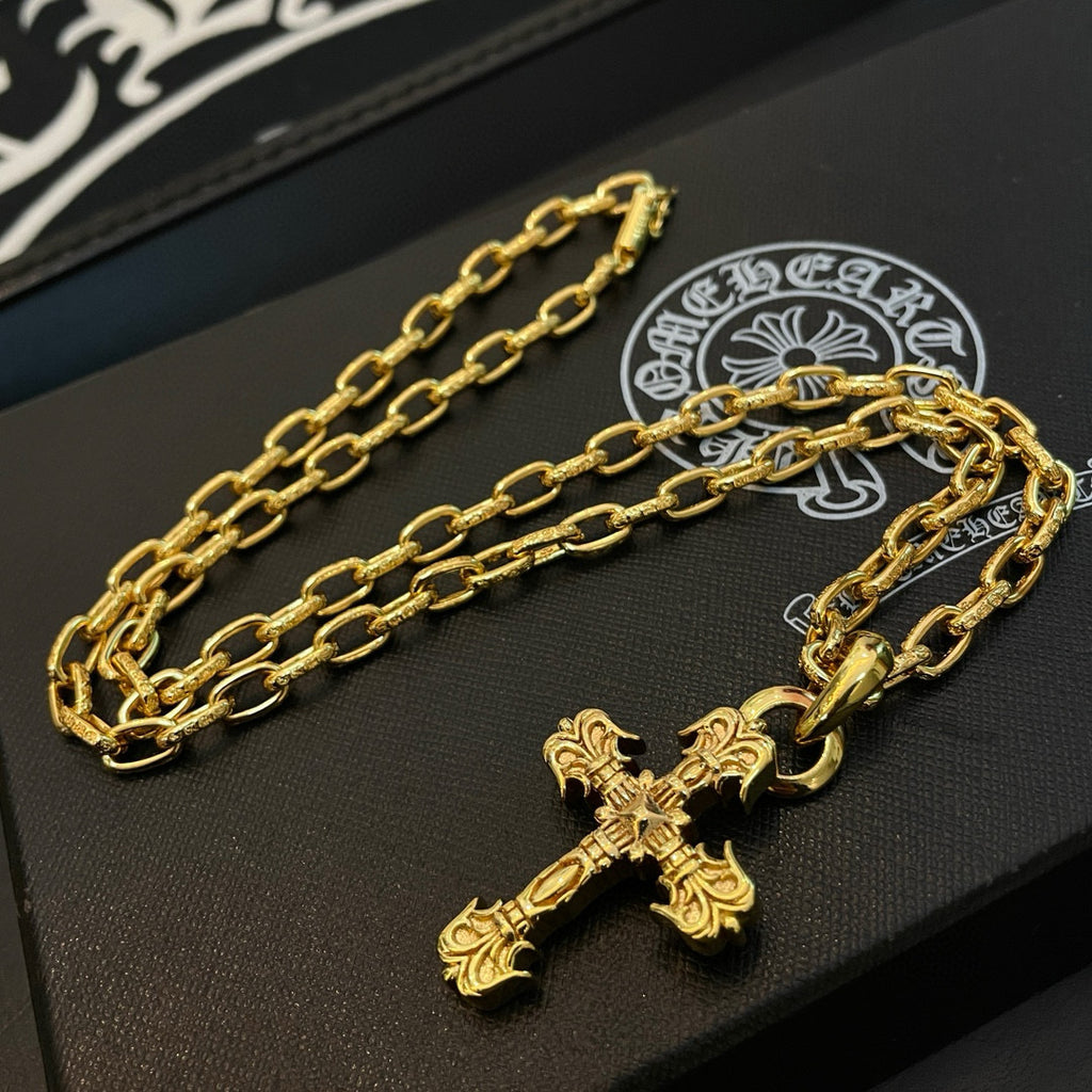 Gold-tone cross pendant necklace laid flat on a black jewelry display tray