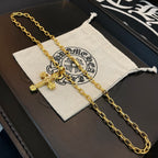 Gold-tone cross pendant necklace resting on a light pouch inside a box