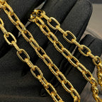 Close-up of gold-tone chain links for a cross pendant necklace