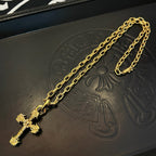 Gold-tone cross pendant on a textured black jewelry box base