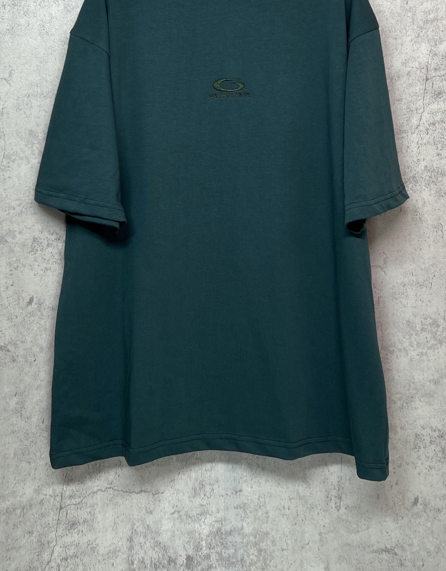 Teal short-sleeve T-shirt front view with small chest emblem and relaxed fit