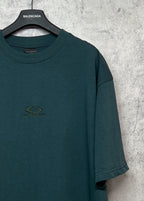 Teal T-shirt chest area with small emblem logo and short sleeves