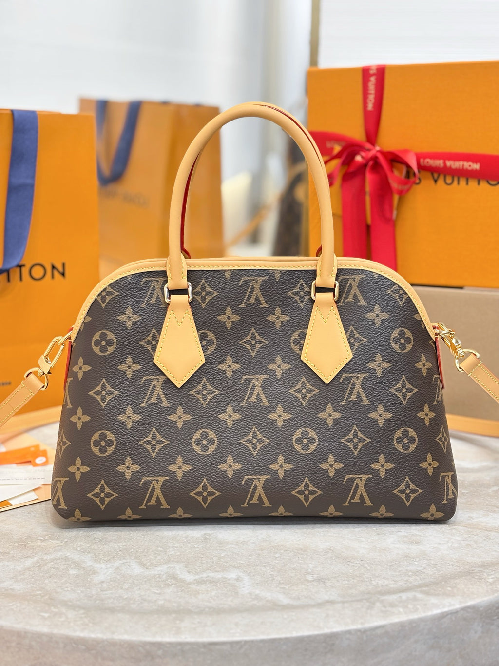 Louis Vuitton monogram handbag with tan handles and tassel-like front accents