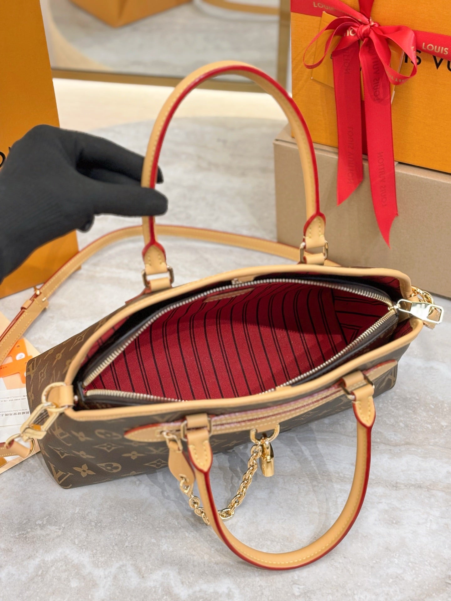 Louis Vuitton monogram bag interior with red striped lining and gold zipper trim